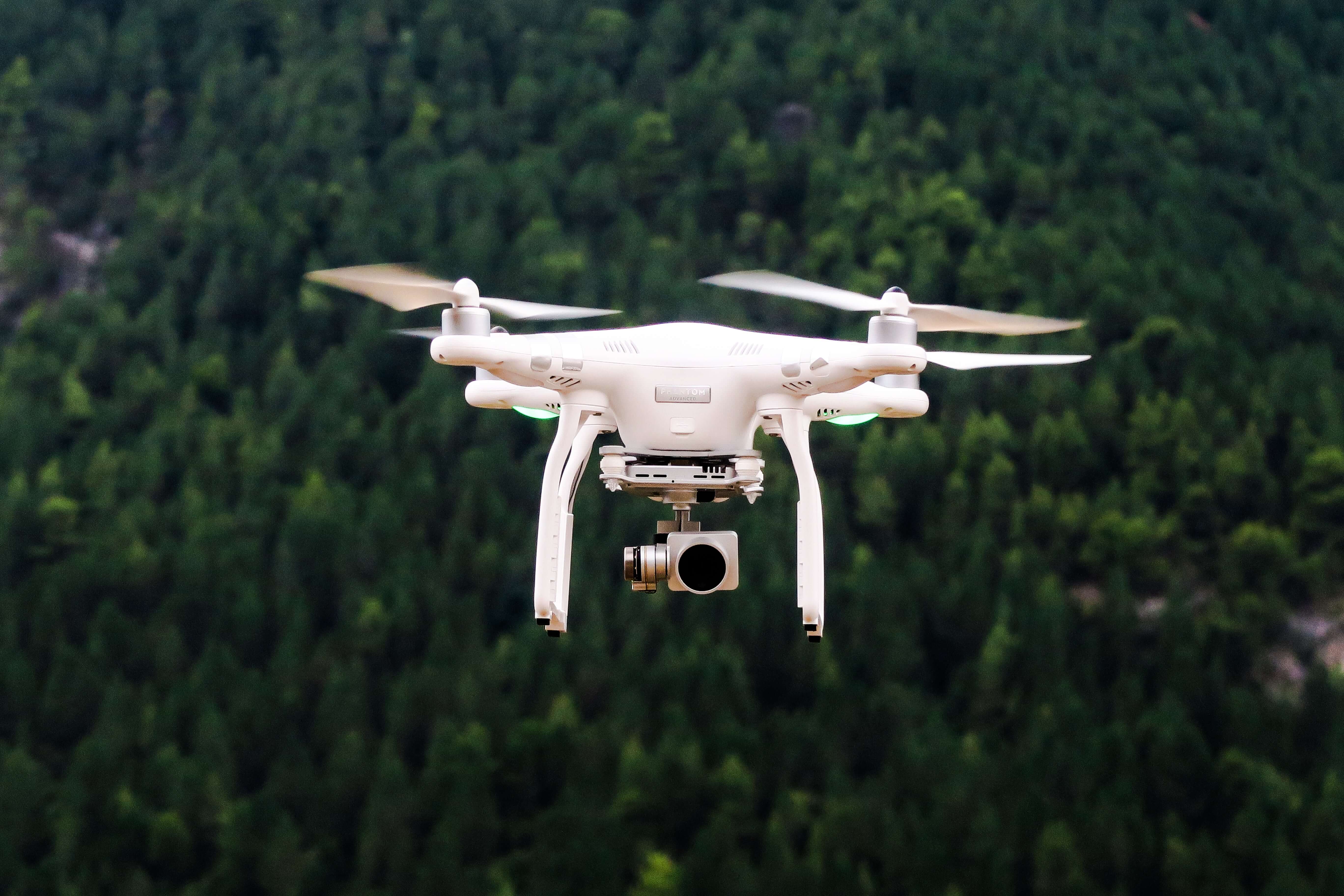 a drone flying over the forest a drone flying over the forest