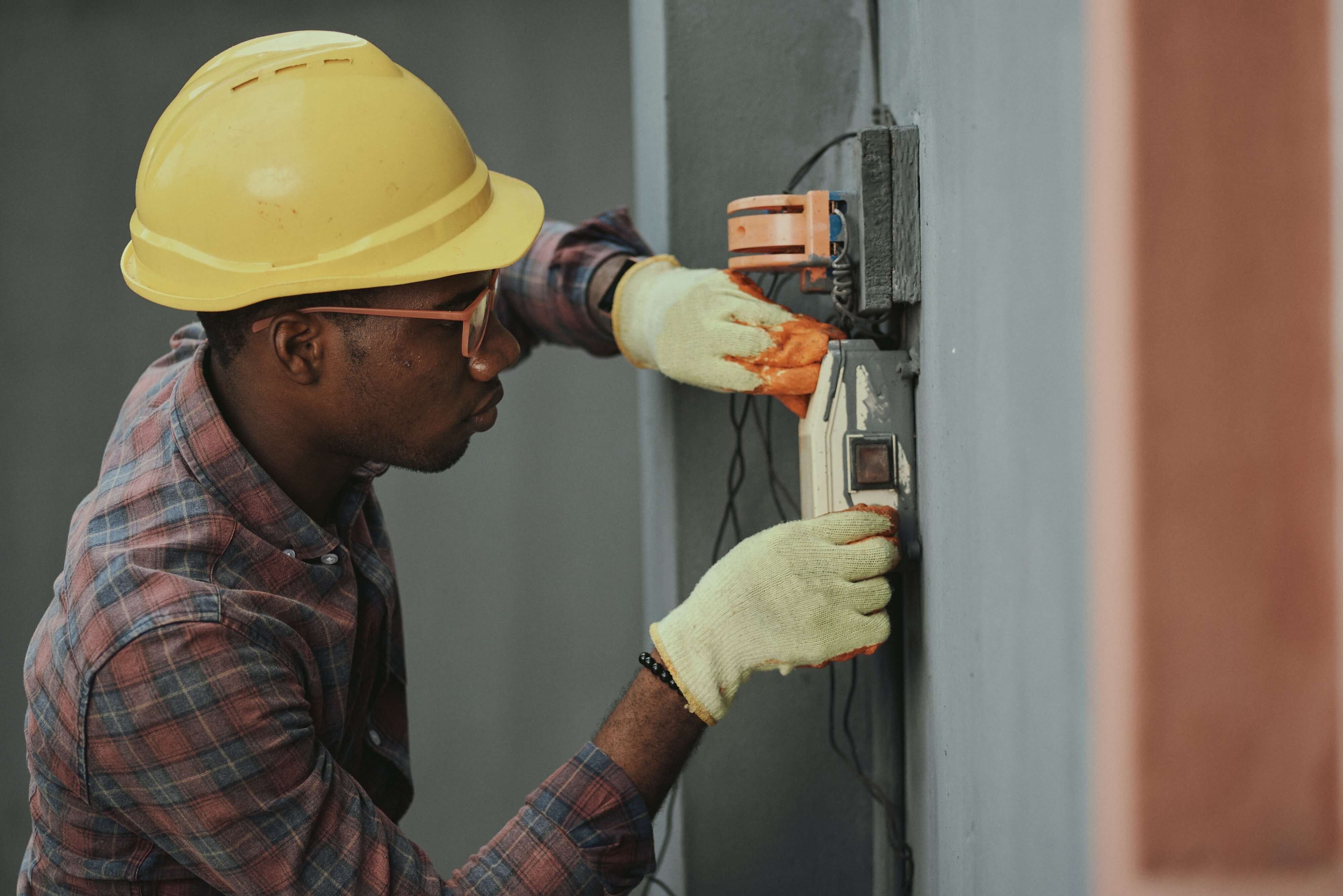 an electrician in a helmet mounts the device